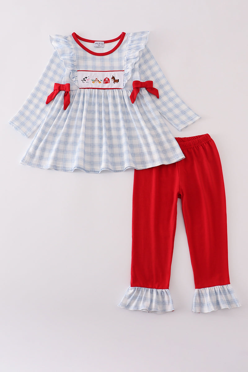 Children's outfit with checkered top and red pants on a light gray background