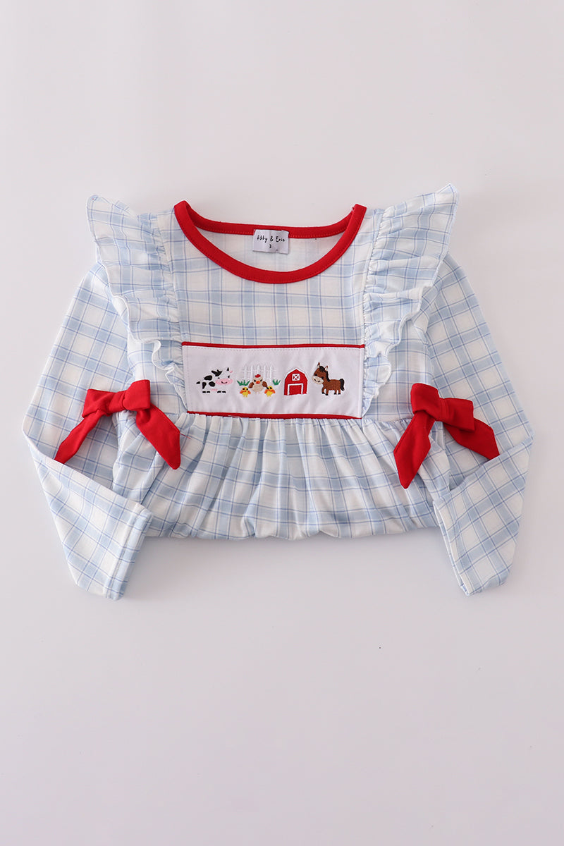 Blue checkered dress with red accents and embroidered details on a light gray background