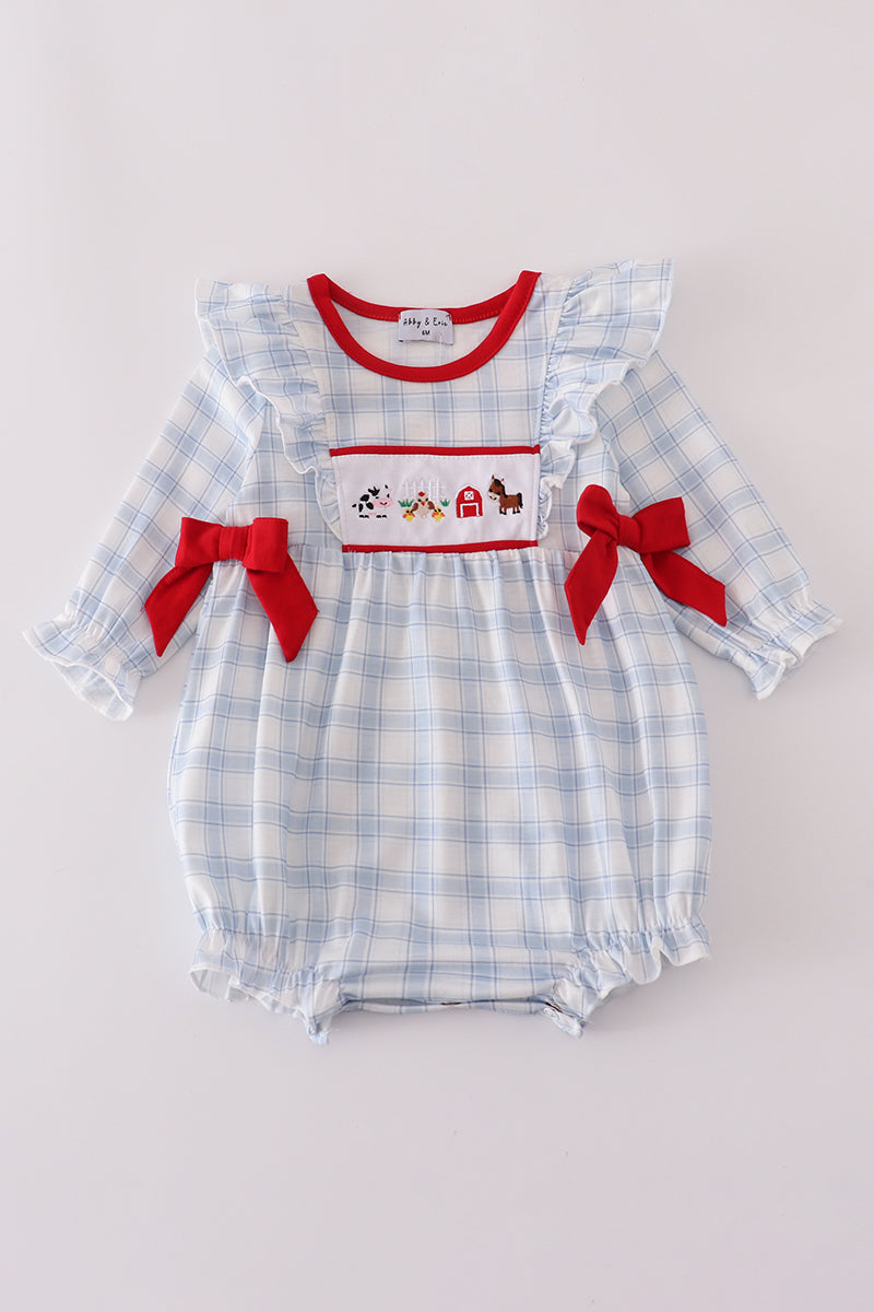 Baby romper with blue plaid pattern, red bows, and farm-themed design on a light gray background