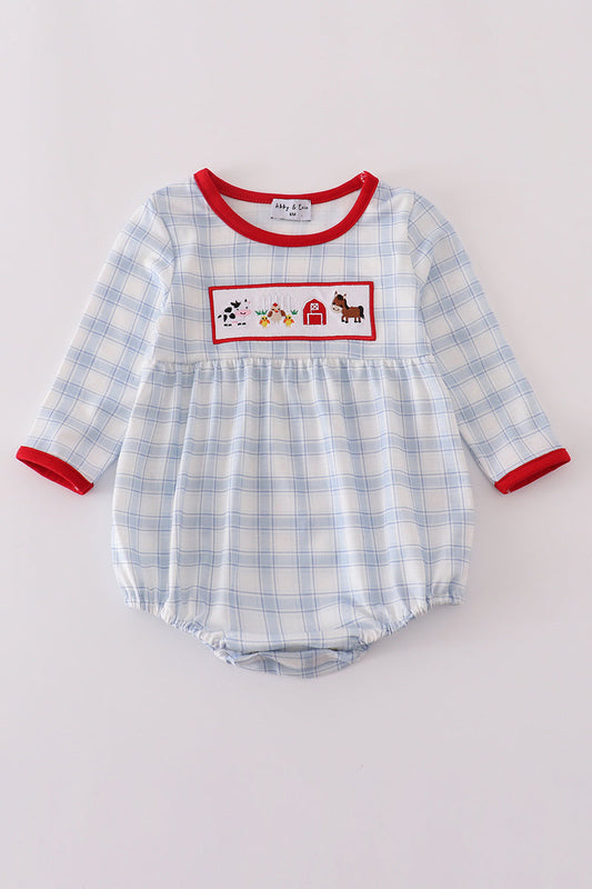 Blue checkered baby romper with red trim and farm-themed design on a light gray background