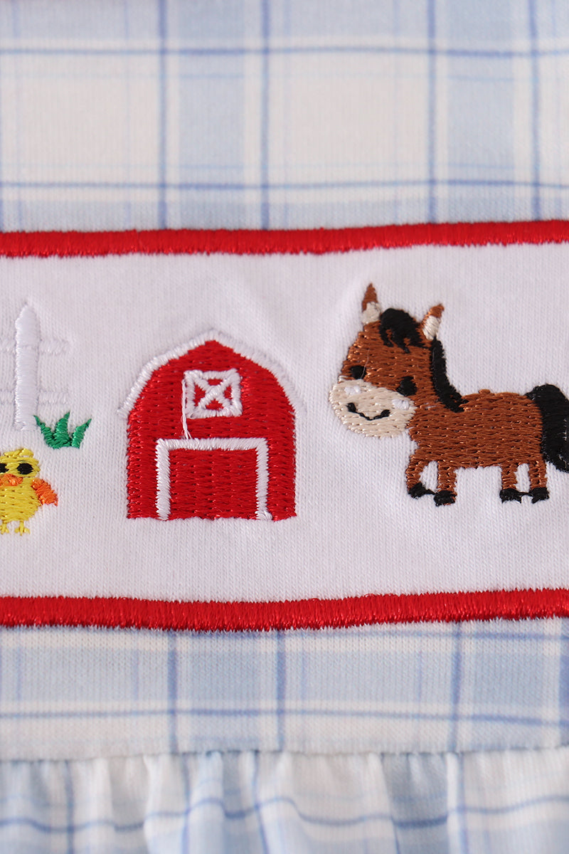 Embroidered fabric with a horse, barn, and chick design on a plaid background