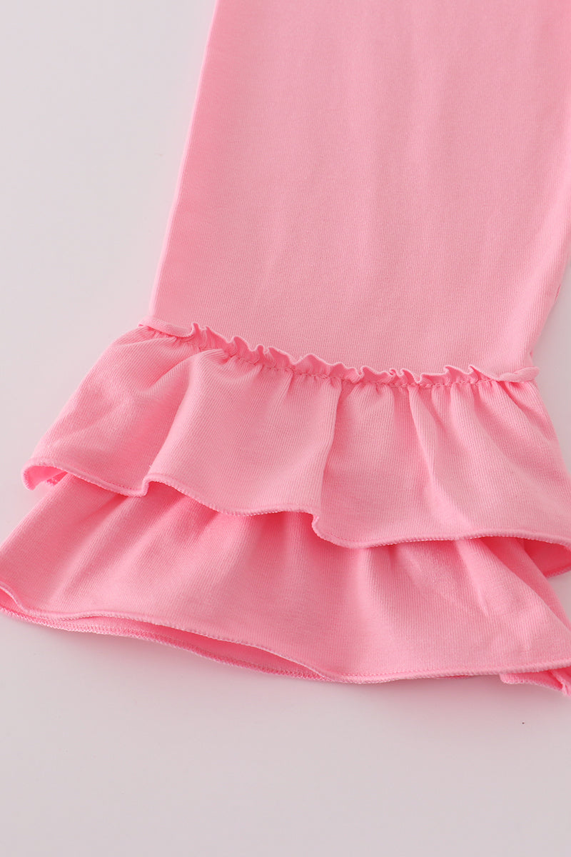 Close-up of a pink dress with ruffled hem on a light gray background