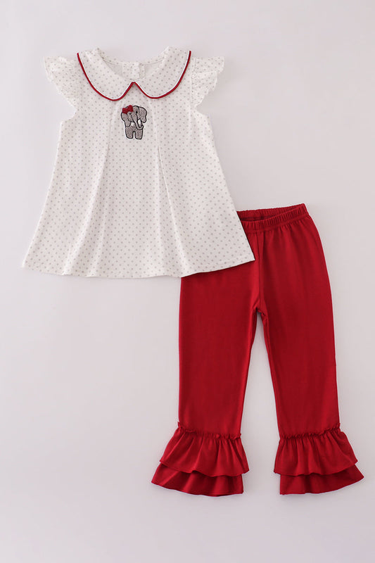 White top with red trim and red ruffled pants on a light gray background
