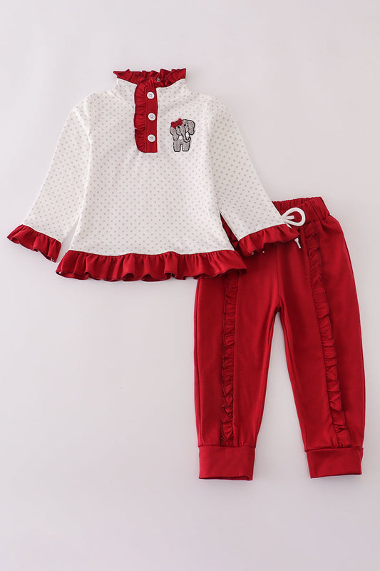 Children's outfit with white top and red pants on a light gray background