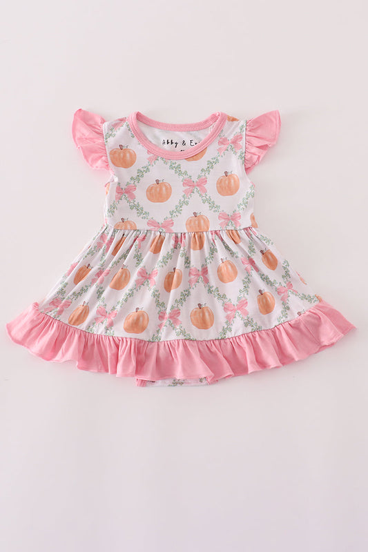 Children's dress with pumpkin pattern and pink ruffles on a light background