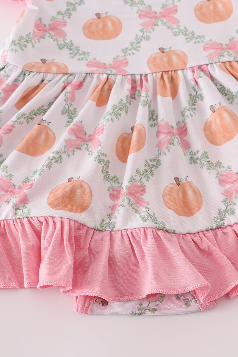 Children's dress with pumpkin and bow pattern on a white background