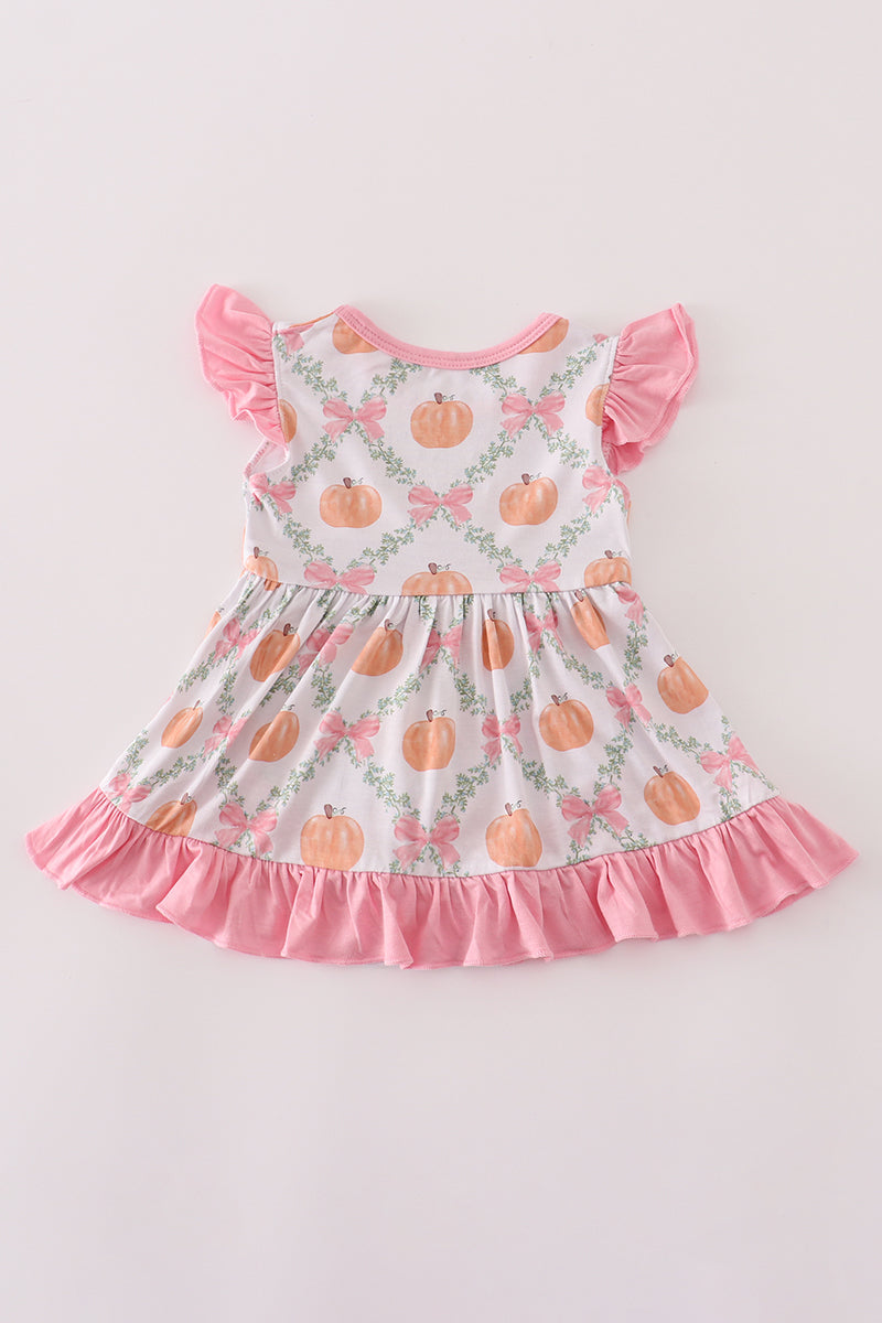 Children's dress with pumpkin pattern on a light pink background