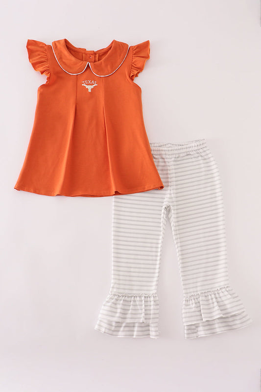 Orange top and striped pants on a light gray background
