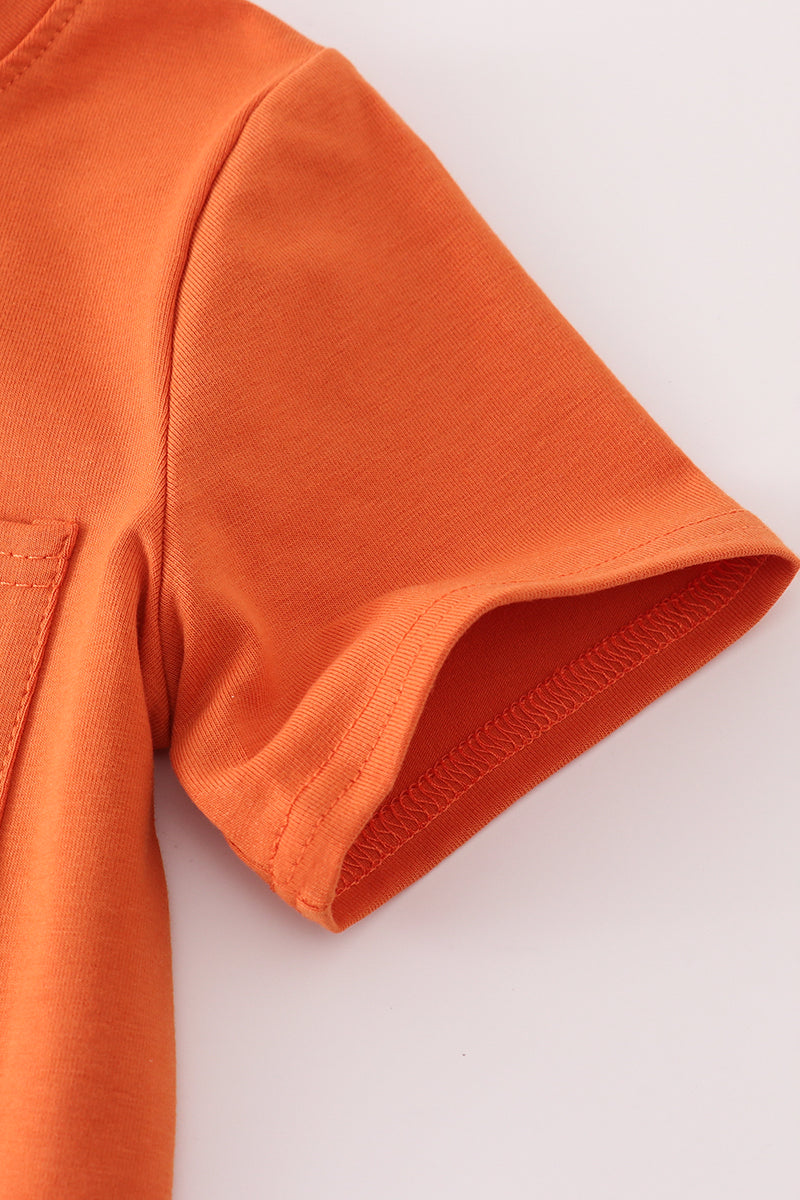 Close-up of an orange shirt sleeve on a white background