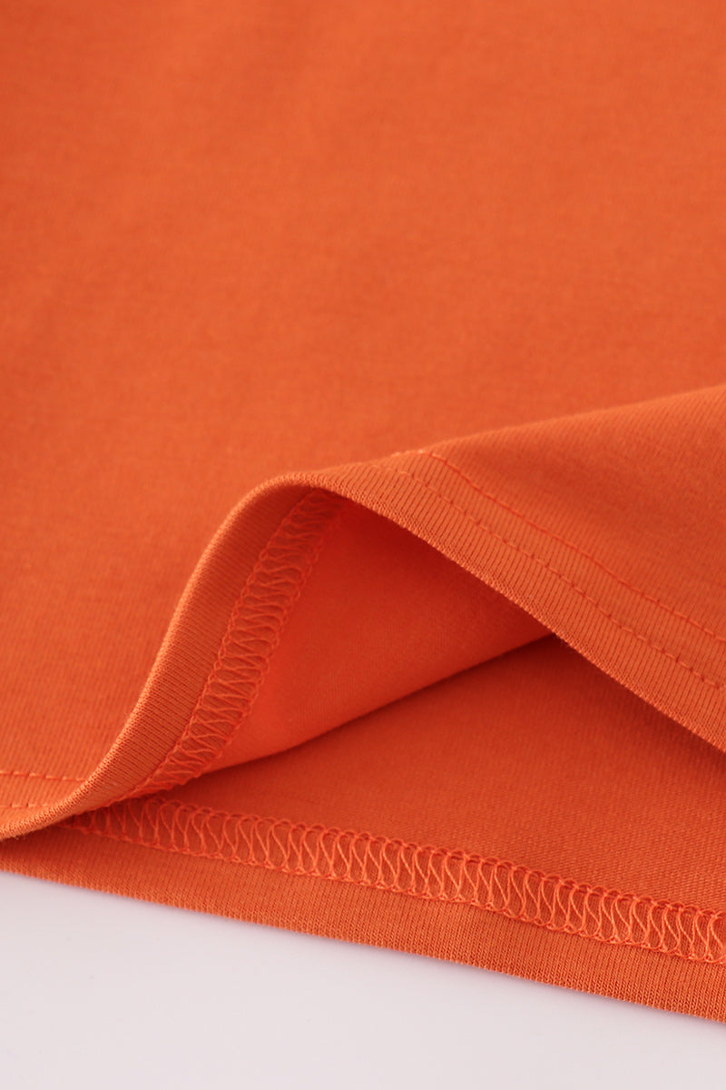 Close-up of orange fabric with visible stitching on a white background