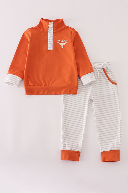 Orange sweatshirt and striped pants set on a light gray background