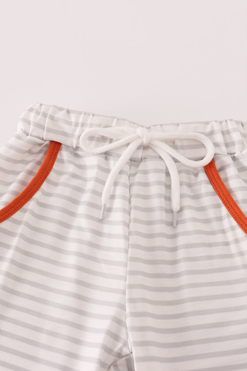 Striped pants with orange trim on a white background