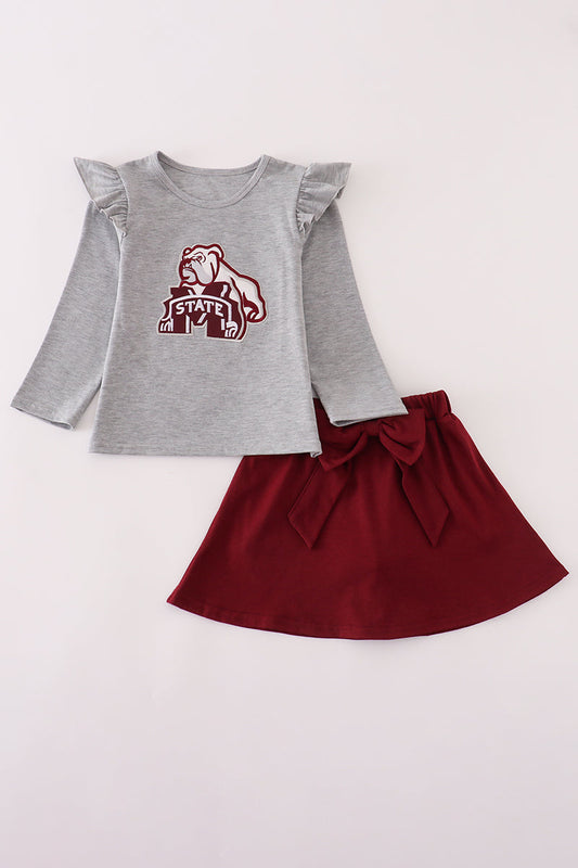 Gray long-sleeve top with ruffled sleeves and maroon skirt on a white background