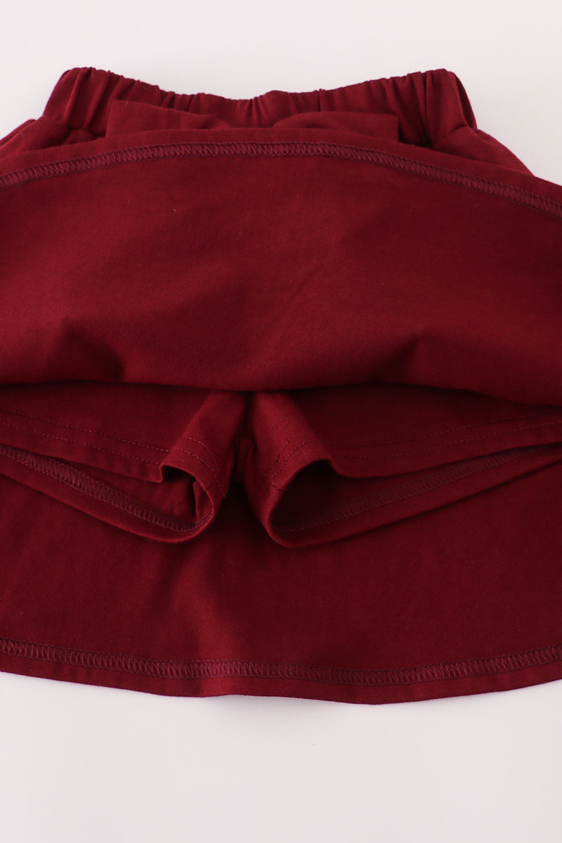 Maroon fabric with ruffled edge on a white background