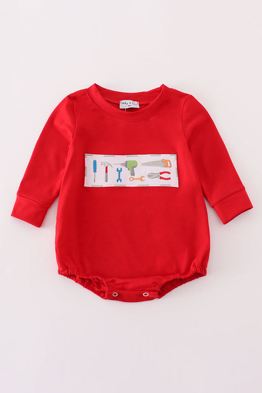 Red baby romper with a colorful graphic on a light gray background