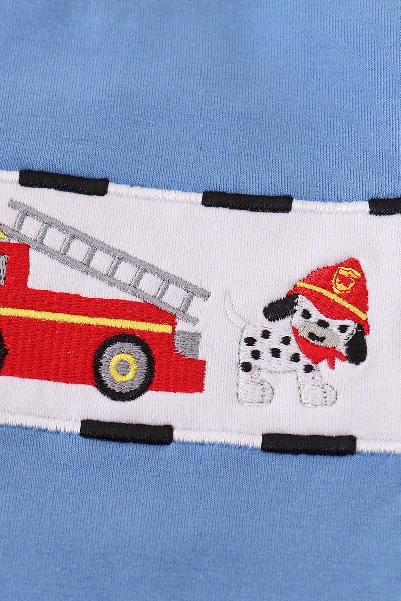 Close-up of a fabric strip with a fire truck and Dalmatian design on a blue background