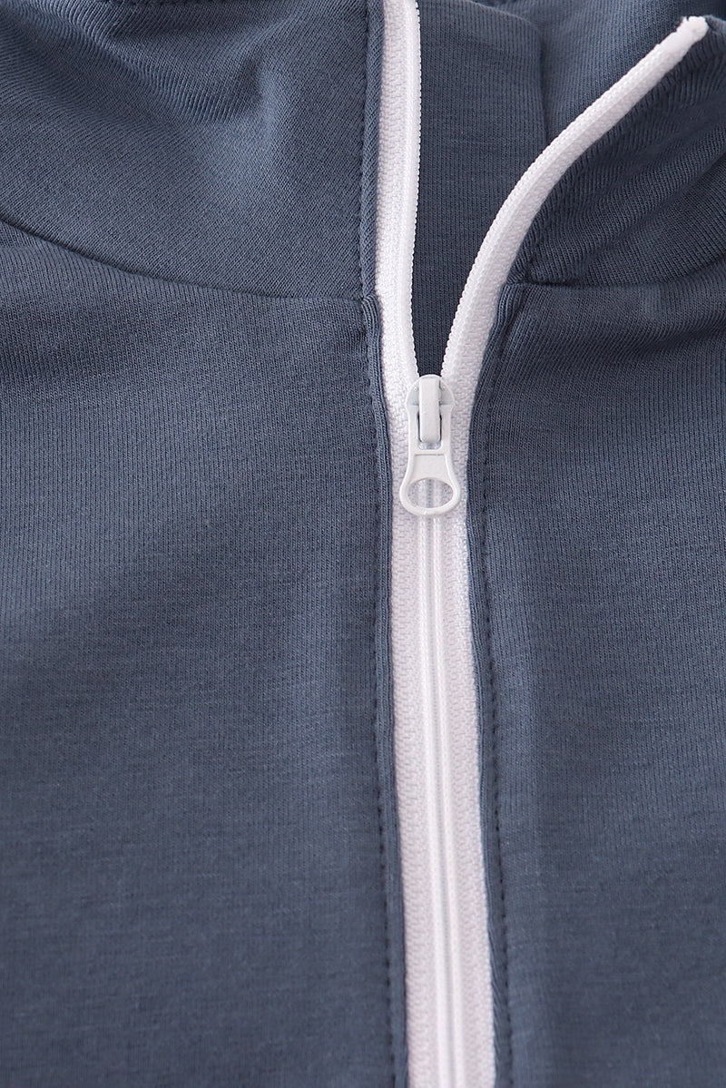 Close-up of a zipper on a dark blue garment with white trim.