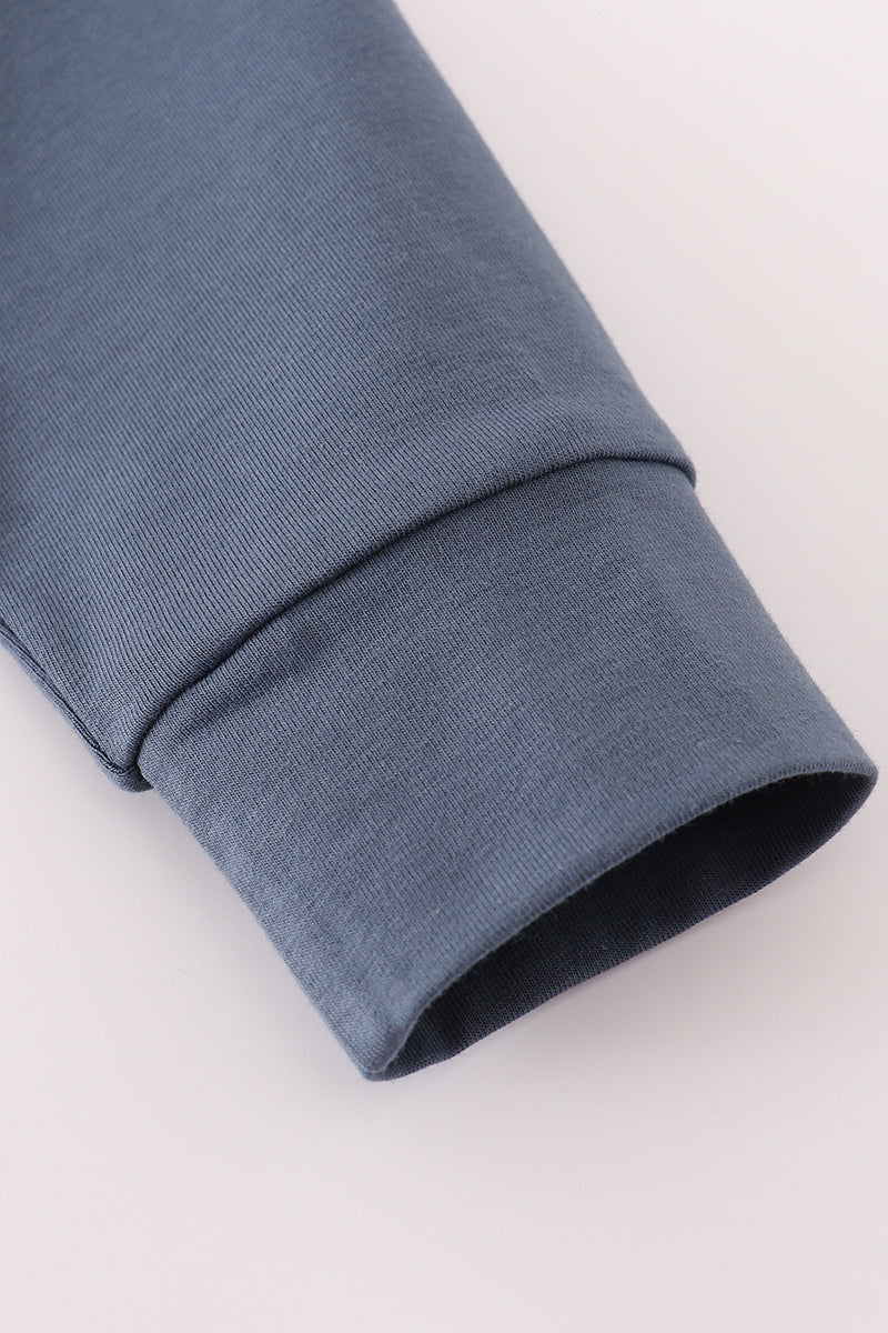 Close-up of a rolled-up blue sleeve on a light gray background