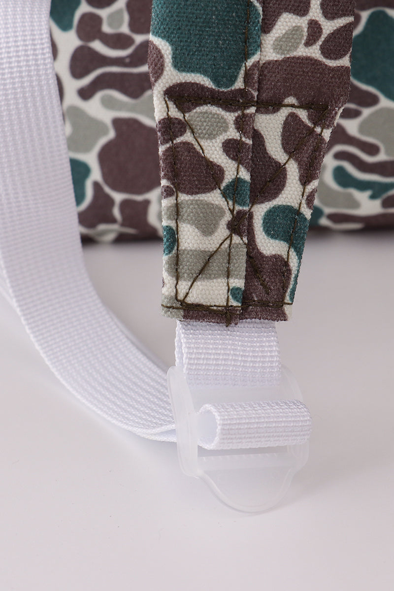 Close-up of camouflage-patterned pants with white socks and shoes on a light background