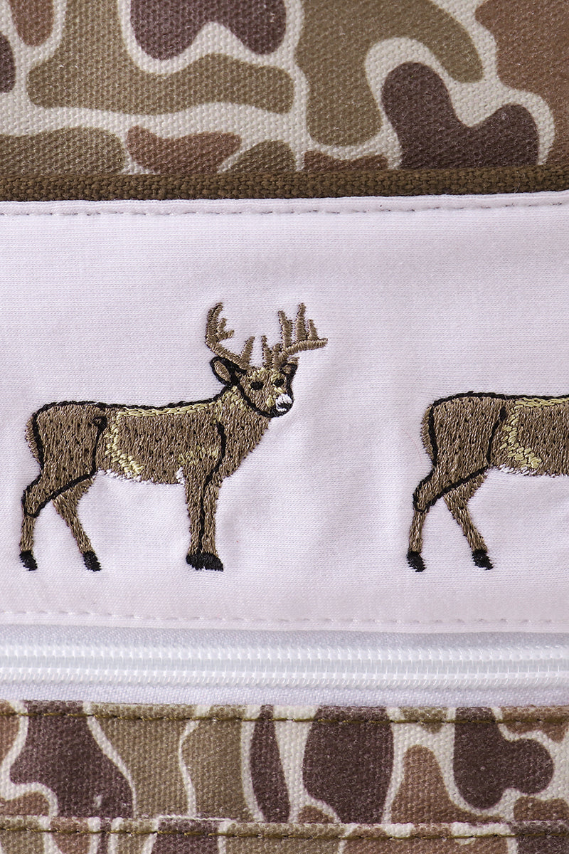Embroidered deer design on a camouflage-patterned fabric