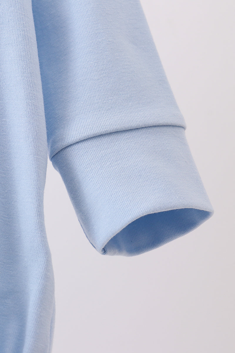 Close-up of a light blue fabric with a textured pattern on a white background