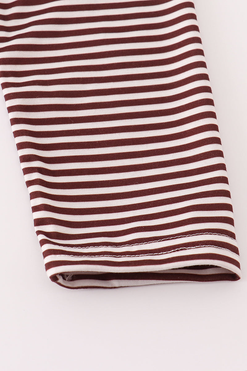 Folded brown and white striped fabric on a light gray background