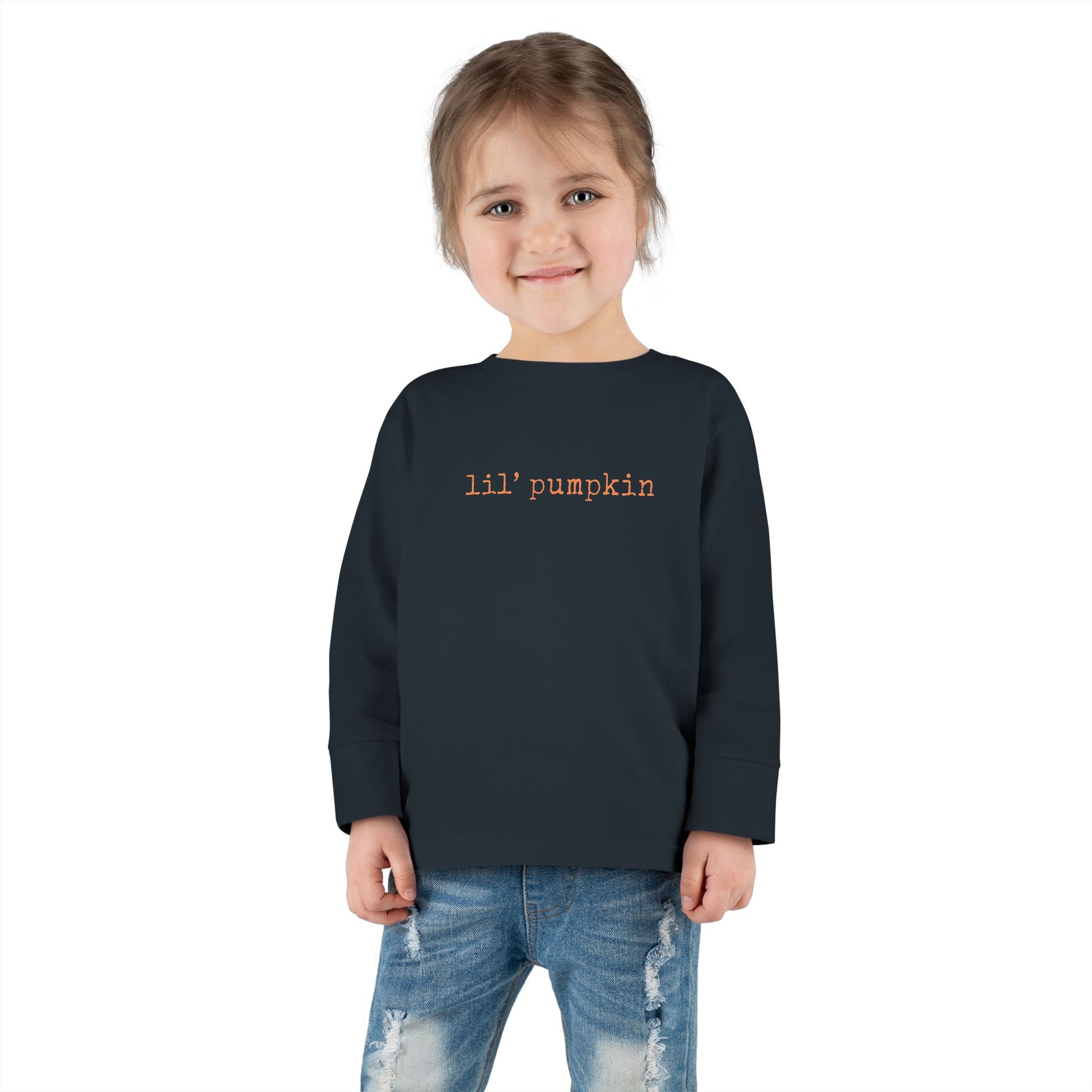 Child wearing a black sweatshirt with 'lil' pumpkin' text on a white background