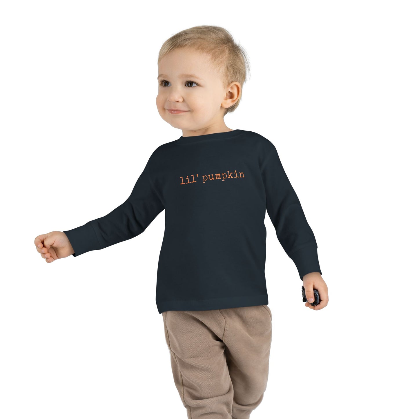 Child wearing a black long-sleeve shirt with 'lil' pumpkin' text on a white background