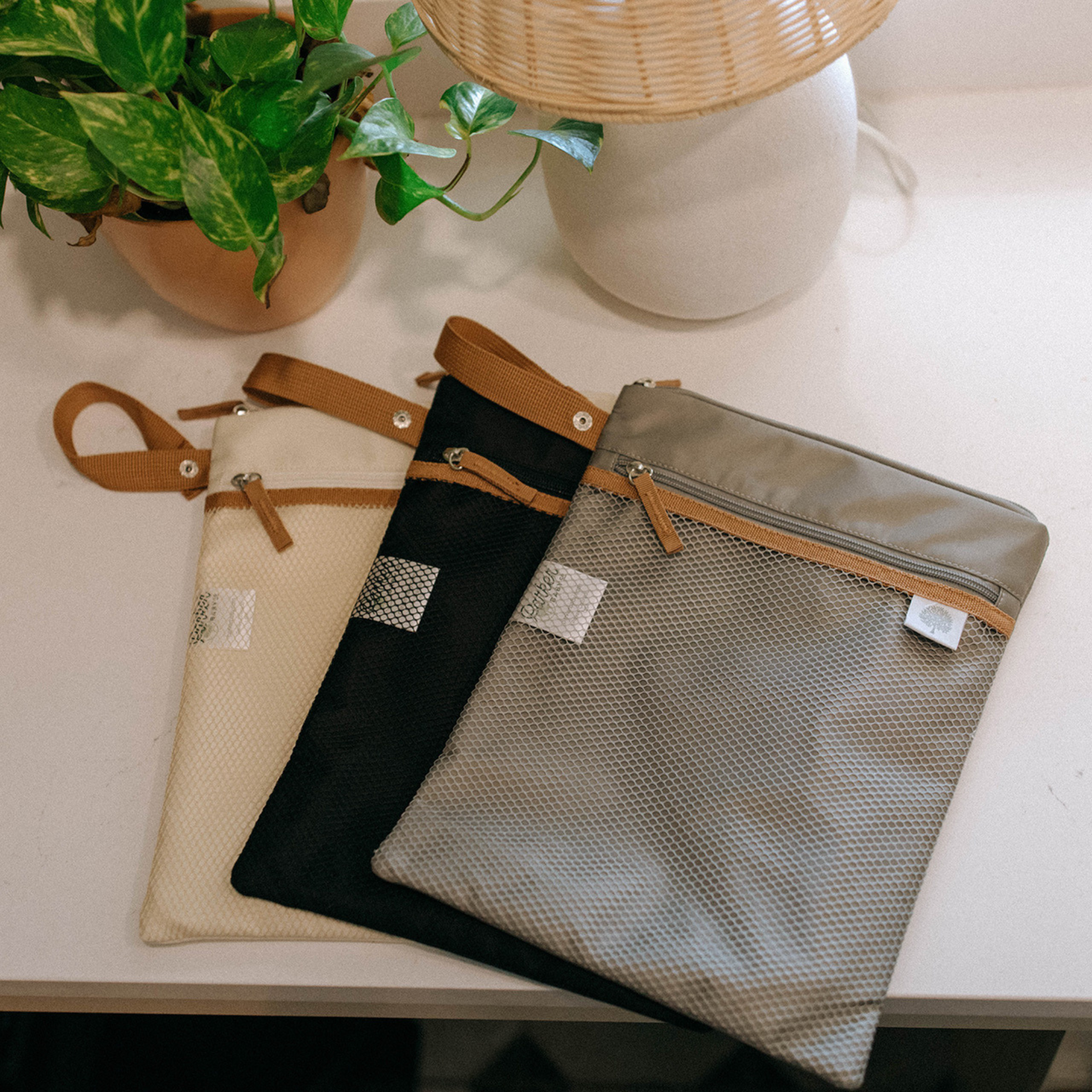 Three fabric bags with zipper on a table.