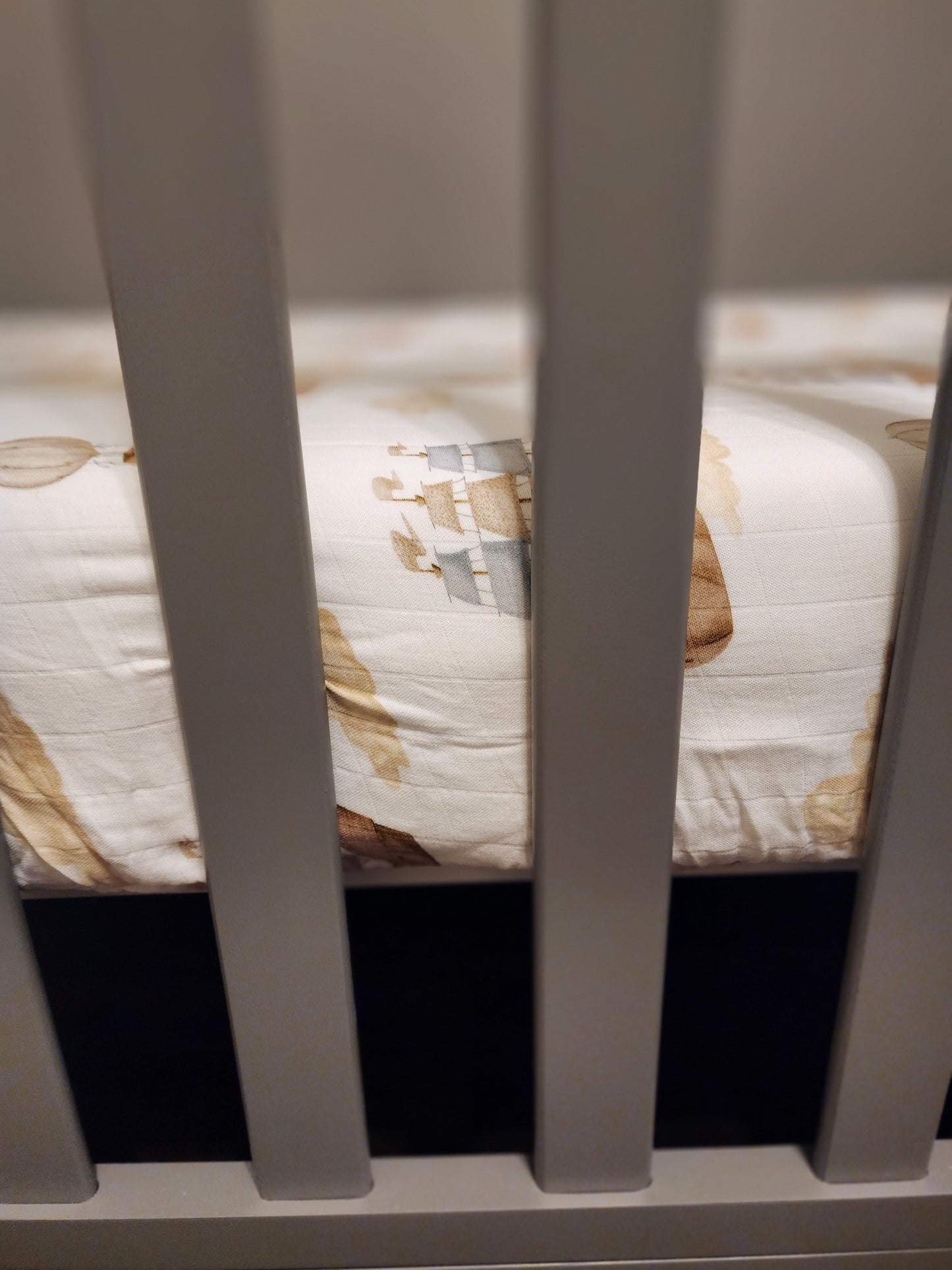Gray crib with a patterned mattress inside