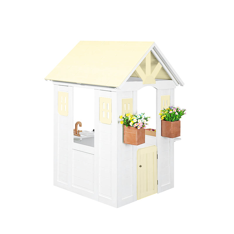 Children's playhouse with a yellow roof and white body, featuring flower boxes and a sink.