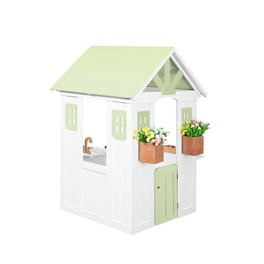 Children's playhouse with a green roof and white body, featuring flower pots and a sink.