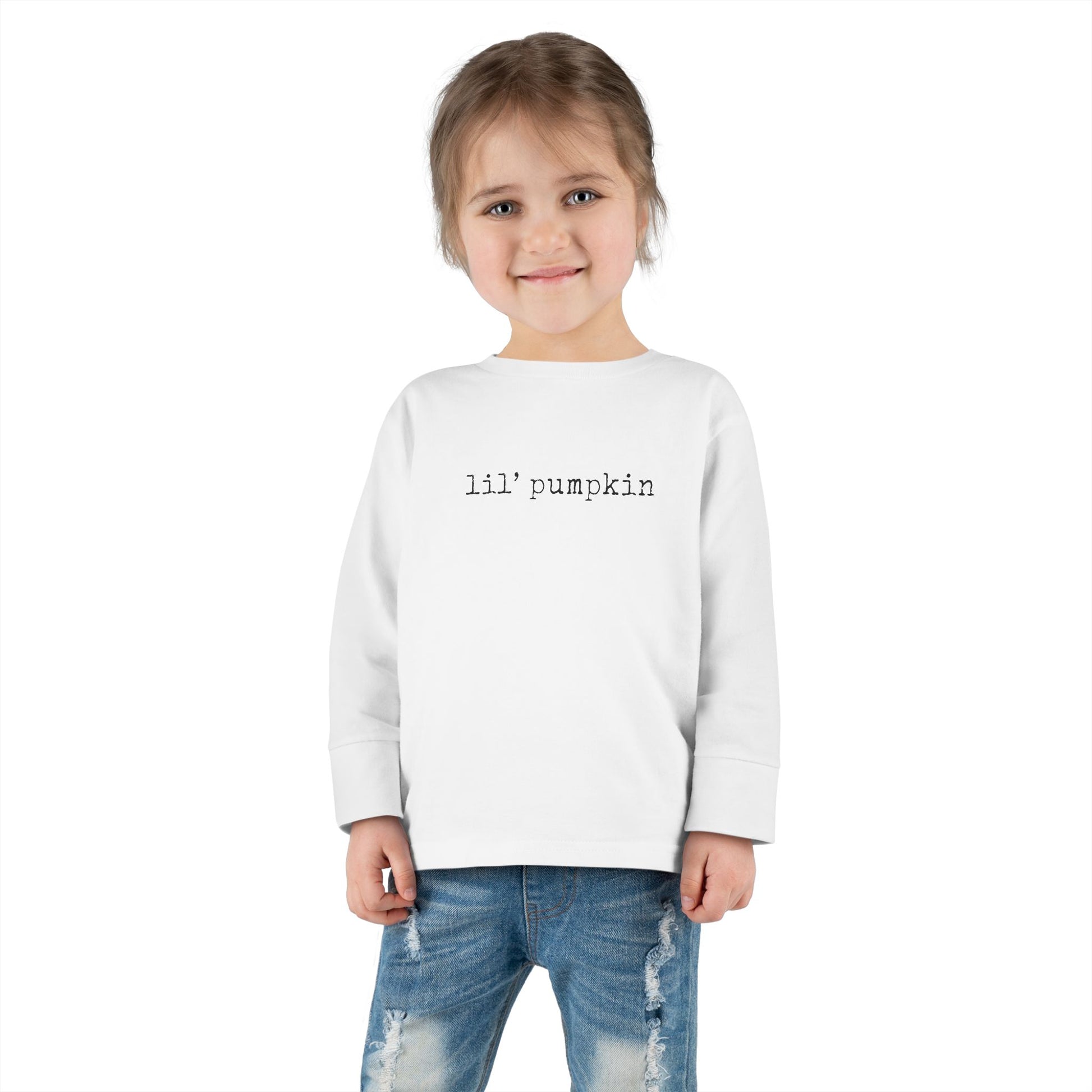 Child wearing a white sweatshirt with 'lil' pumpkin' text on a white background