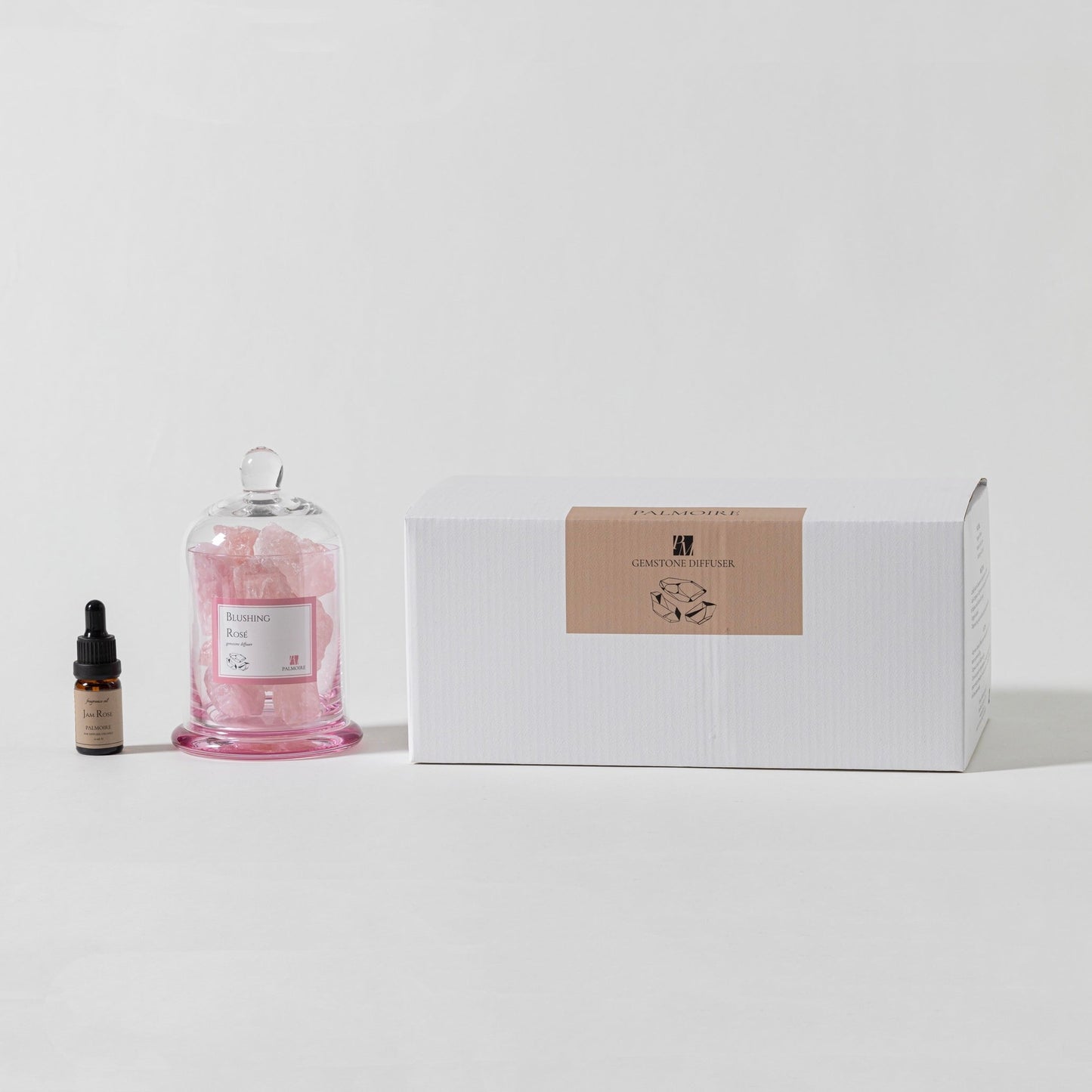 Pink glass jar with dropper bottle and white box on a light gray background