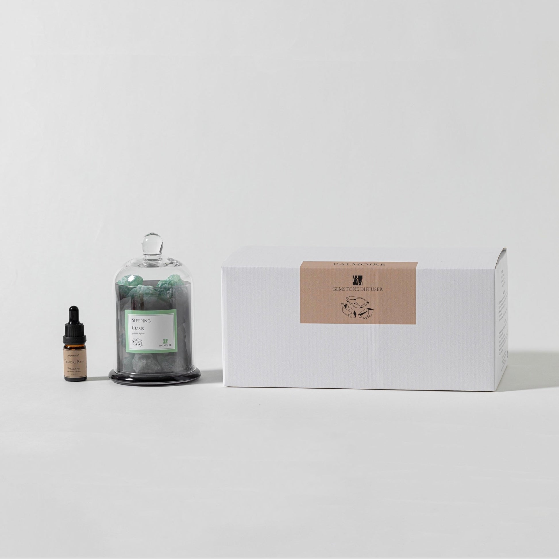 Bottle of essential oil, dropper bottle, and a box on a white surface