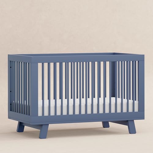 Blue crib with white mattress on a beige background
