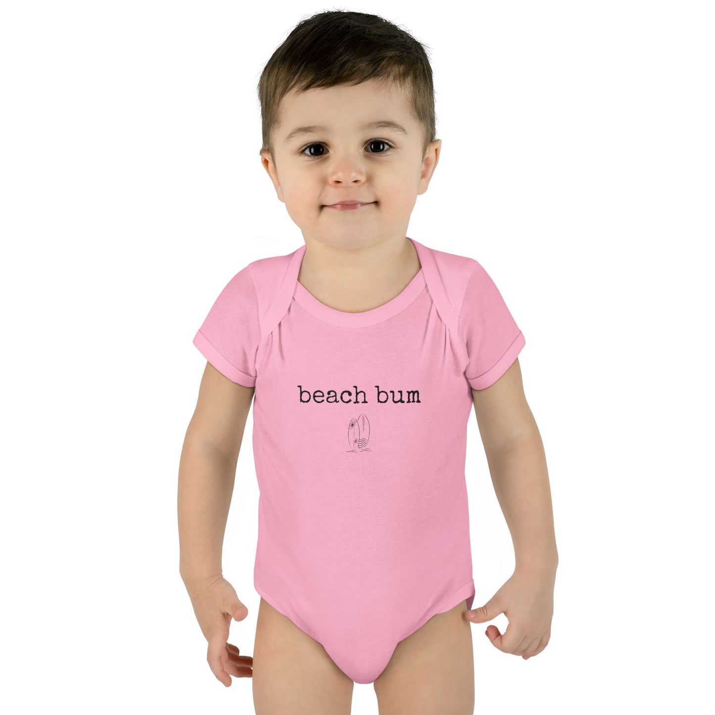Child wearing a pink 'beach bum' onesie on a white background