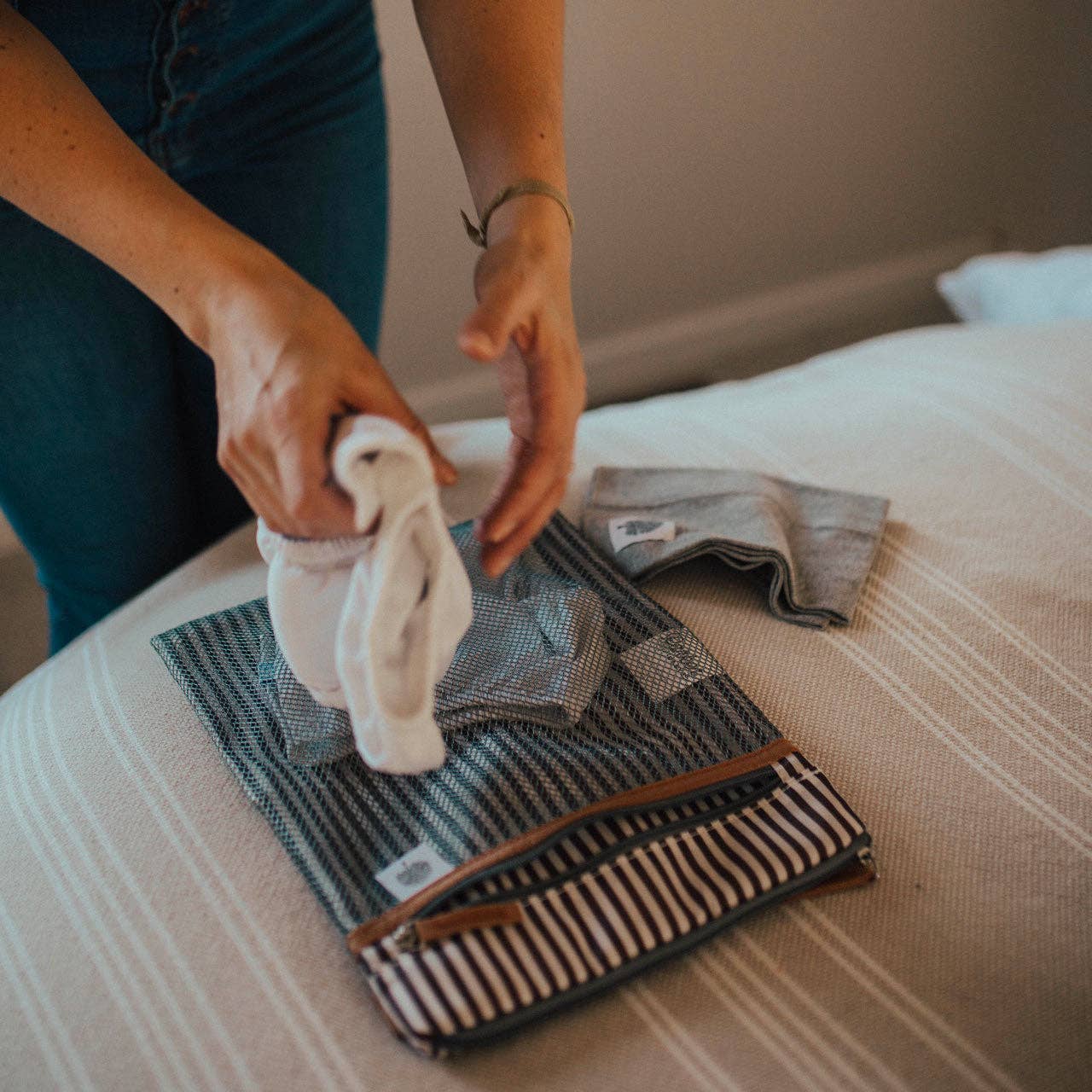 Person organizing fabric items on a table