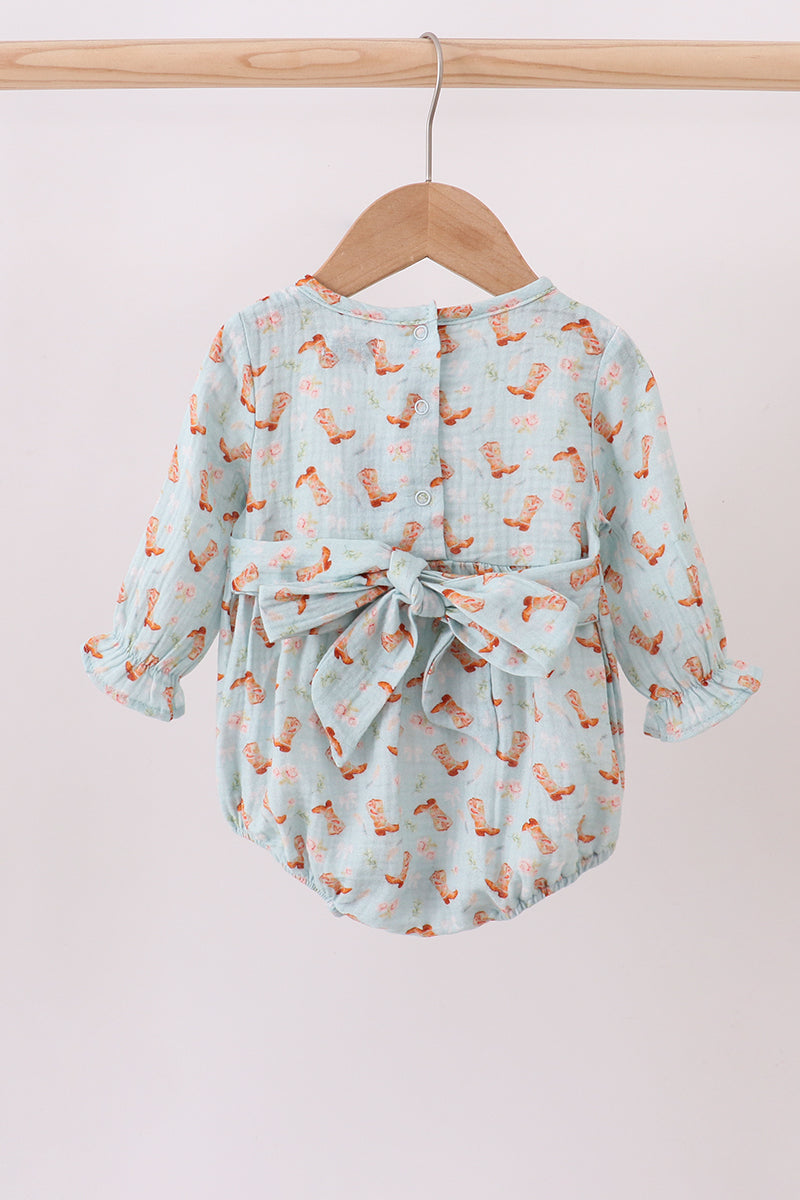 Baby dress with fox pattern on a wooden hanger against a light pink background