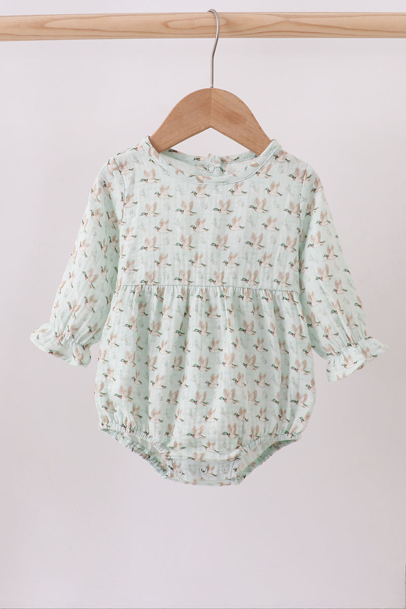 Mint green baby romper with floral pattern on a wooden hanger against a white background