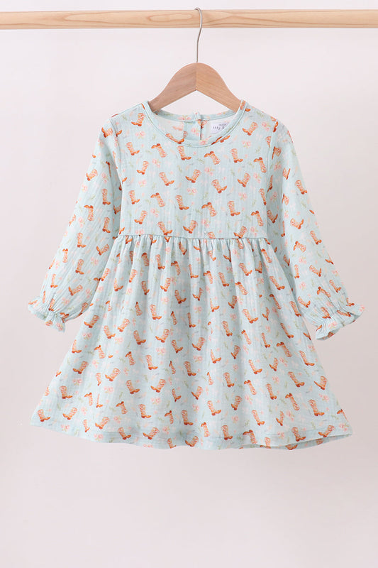Light blue dress with fox pattern on a wooden hanger against a pink background