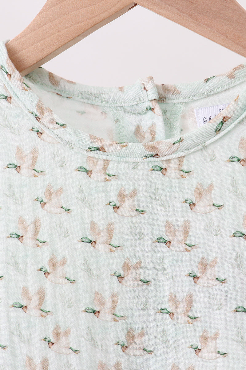 Baby romper with bunny and carrot pattern on a light green background