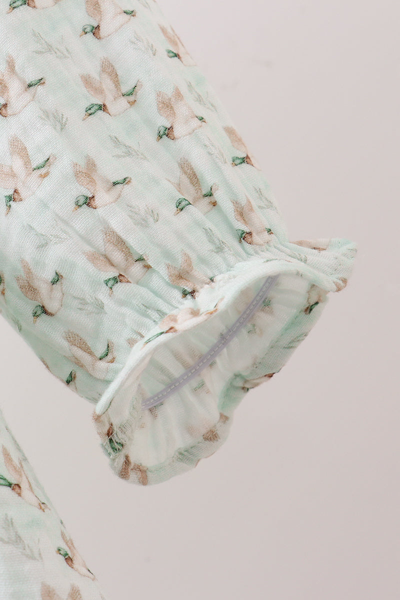 Swaddle blanket with bird pattern on a light pink background