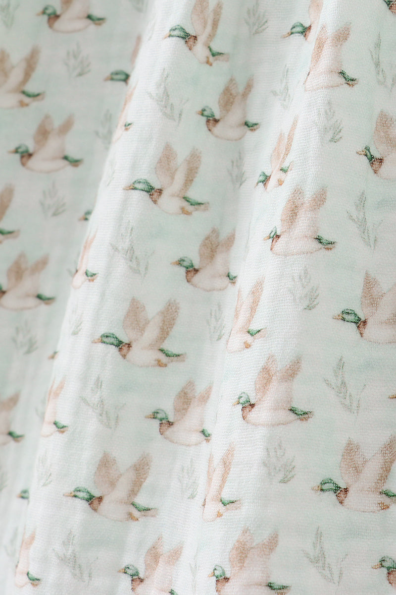 Fabric with duck pattern on a light green background