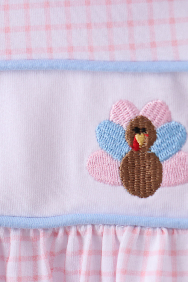 Baby romper with embroidered turkey design on a pink checkered background
