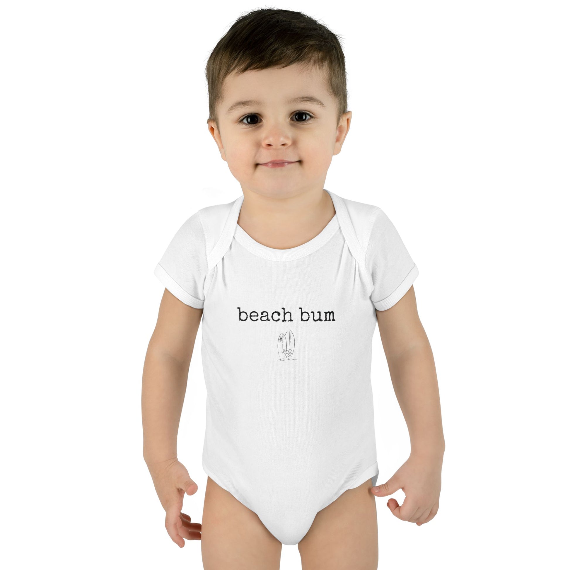 Child wearing a white onesie with 'beach bum' text on a white background