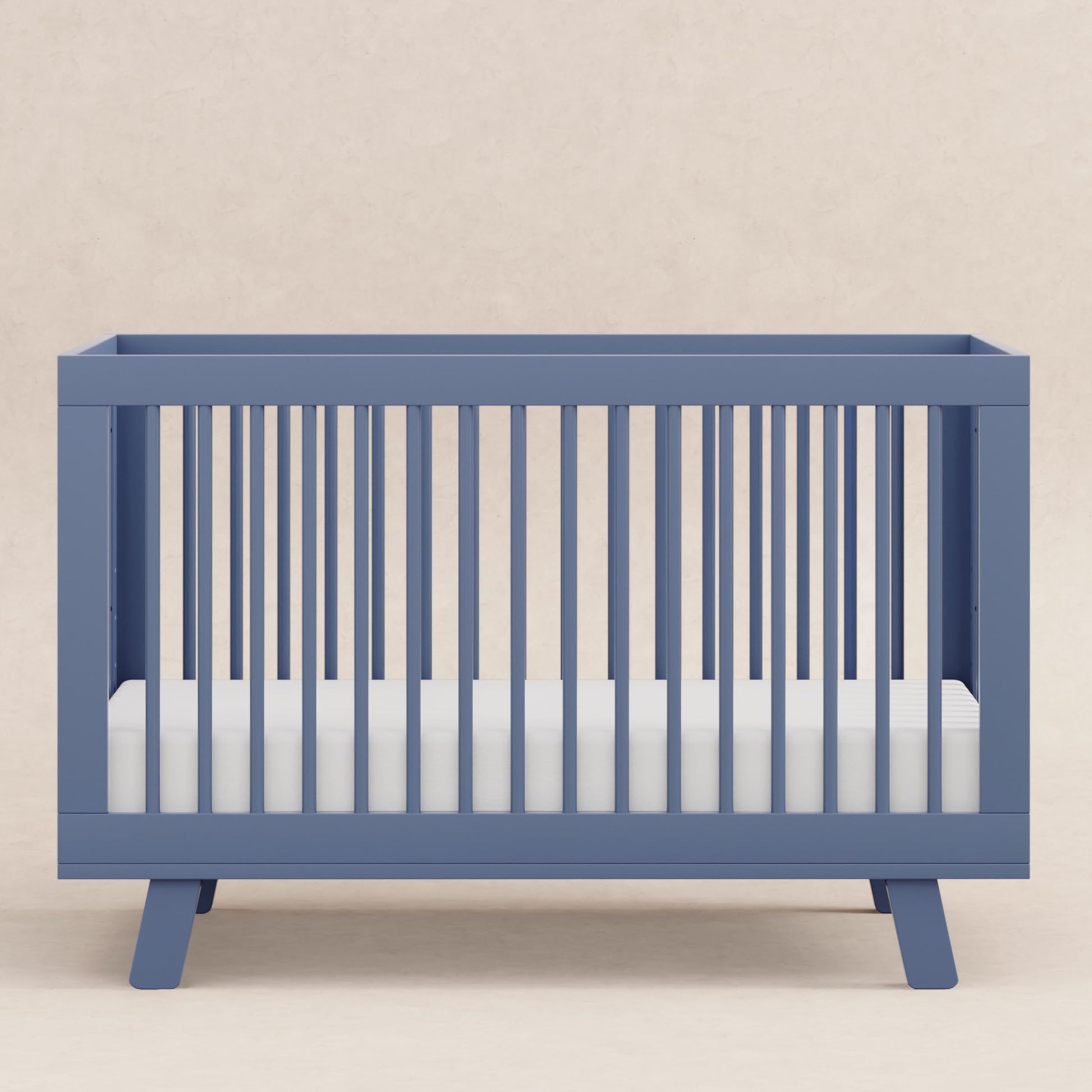 Blue crib with white mattress on a beige background