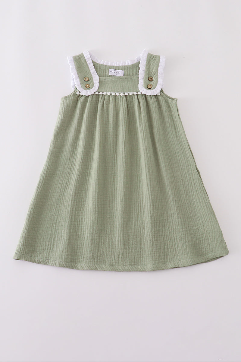 Green dress with white collar and buttons on a light gray background