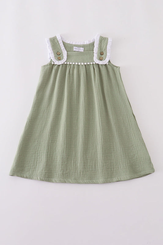 Green dress with white collar and buttons on a light gray background