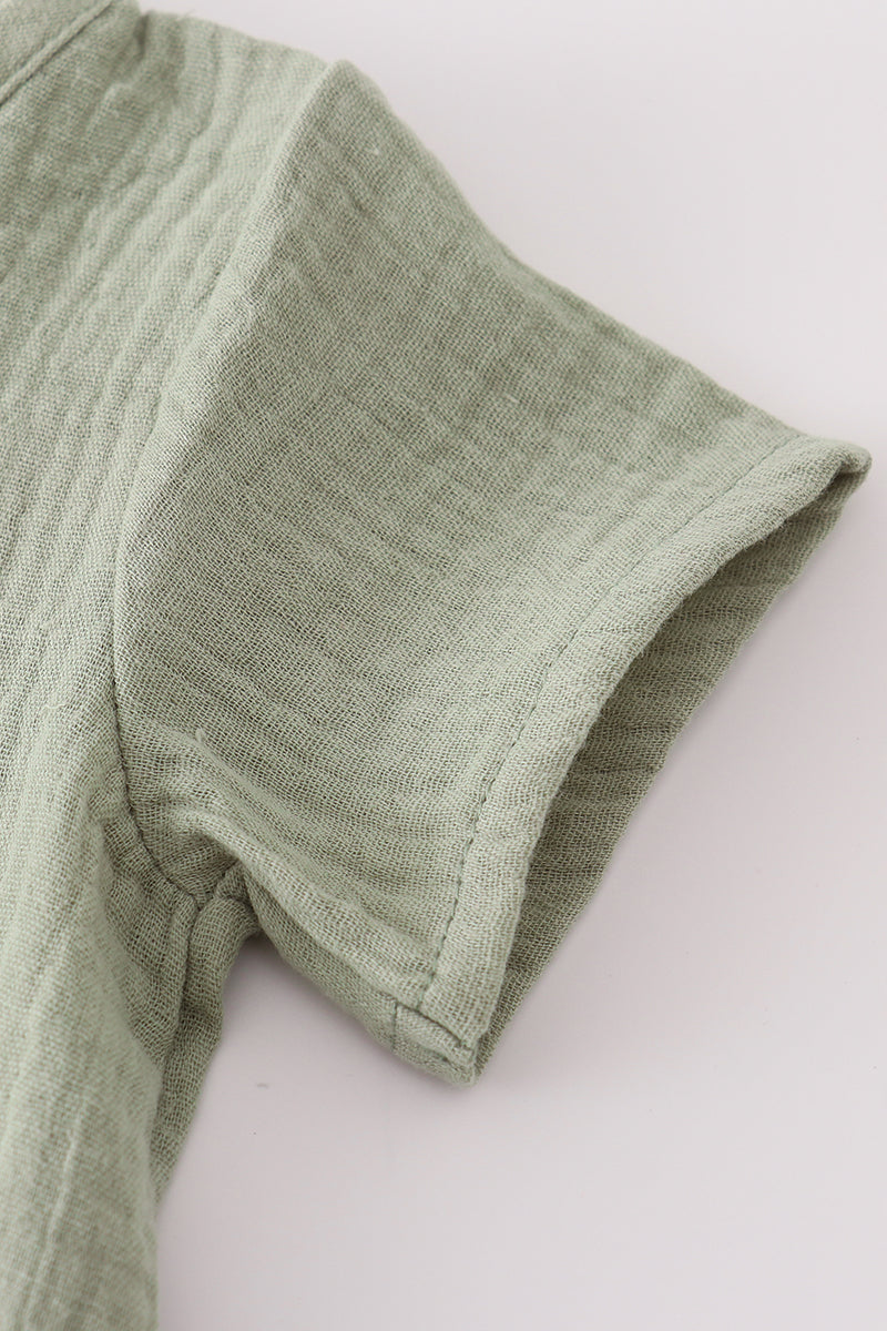Green fabric with a textured pattern on a white background